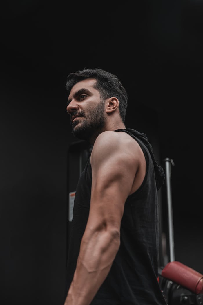 Close-up of a muscular man in a gym, showcasing strength and fitness determination.